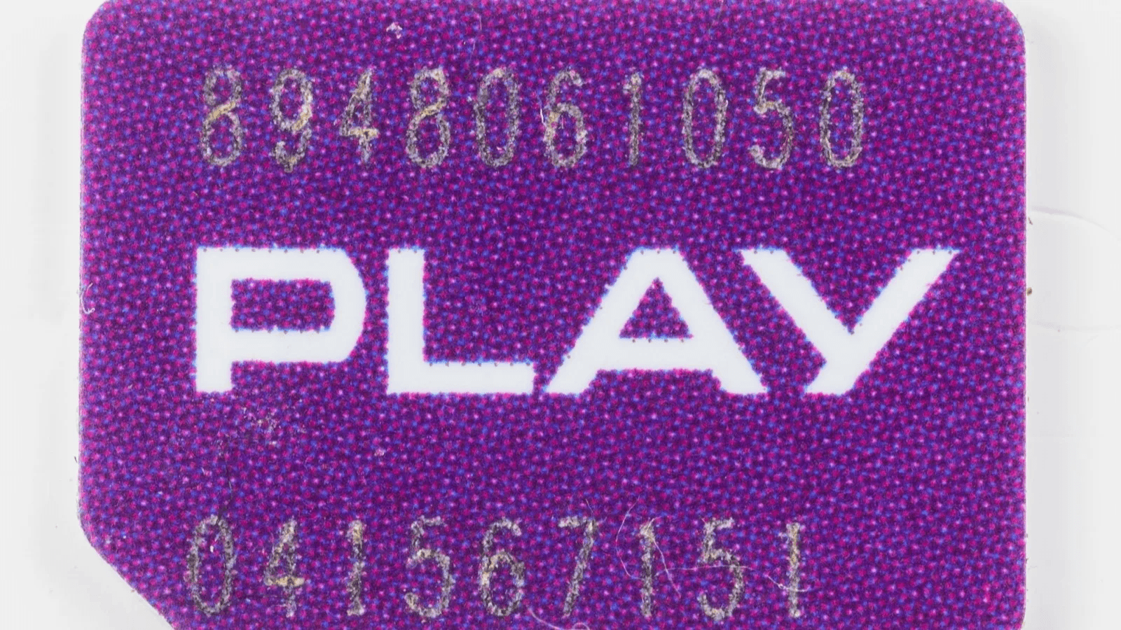 A hand holding a small SIM card beside a smartphone, representing phone number identity in private messaging.