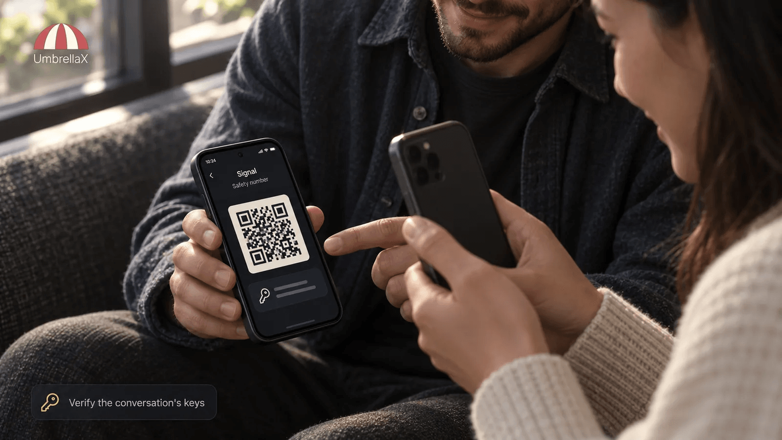 Two people compare a Signal safety number on their phones in person.