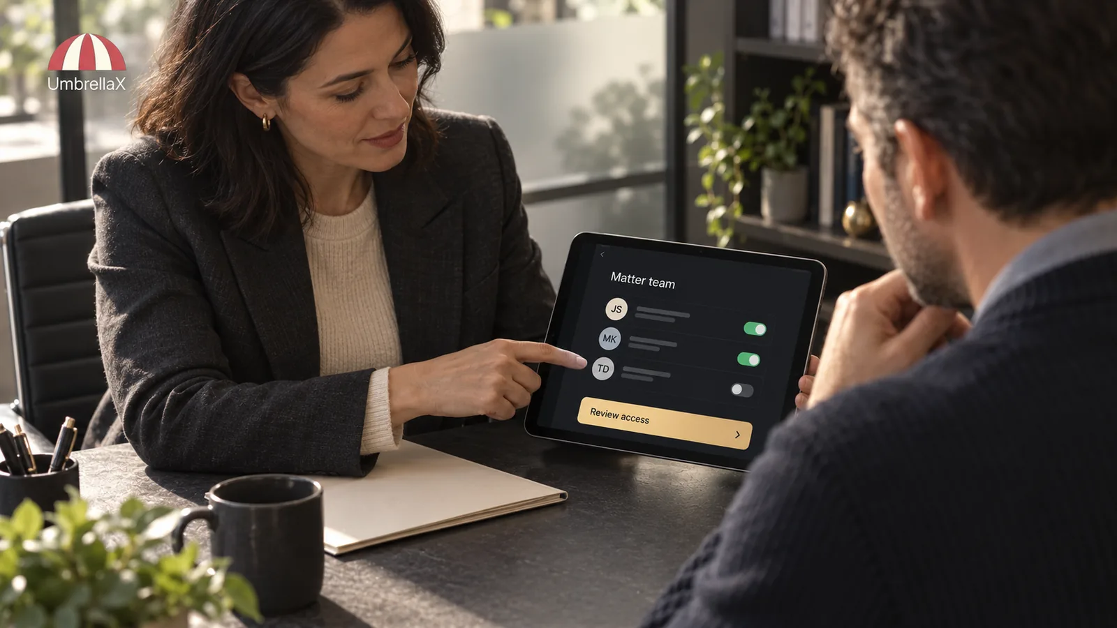 A lawyer and client review a confidential matter team on a tablet.